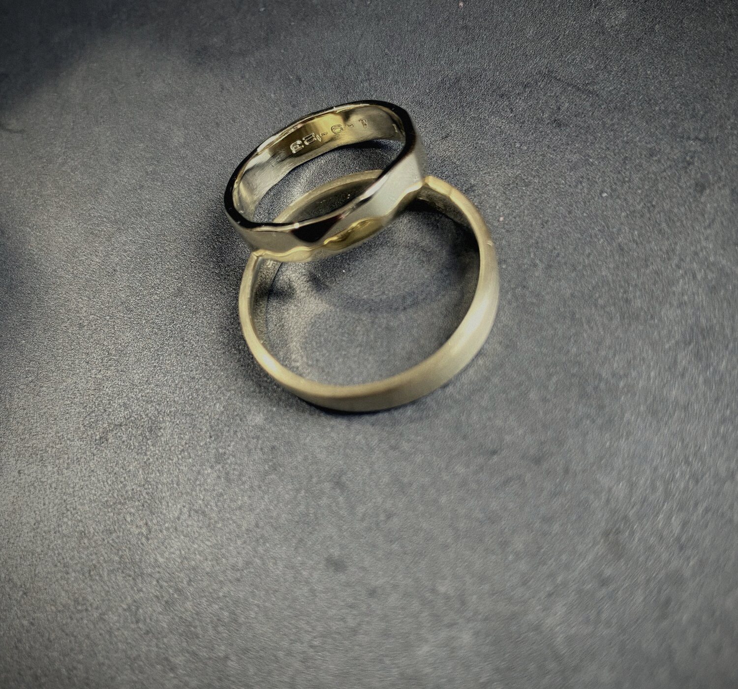 Twee gouden ringen op een betonnen ondergrond