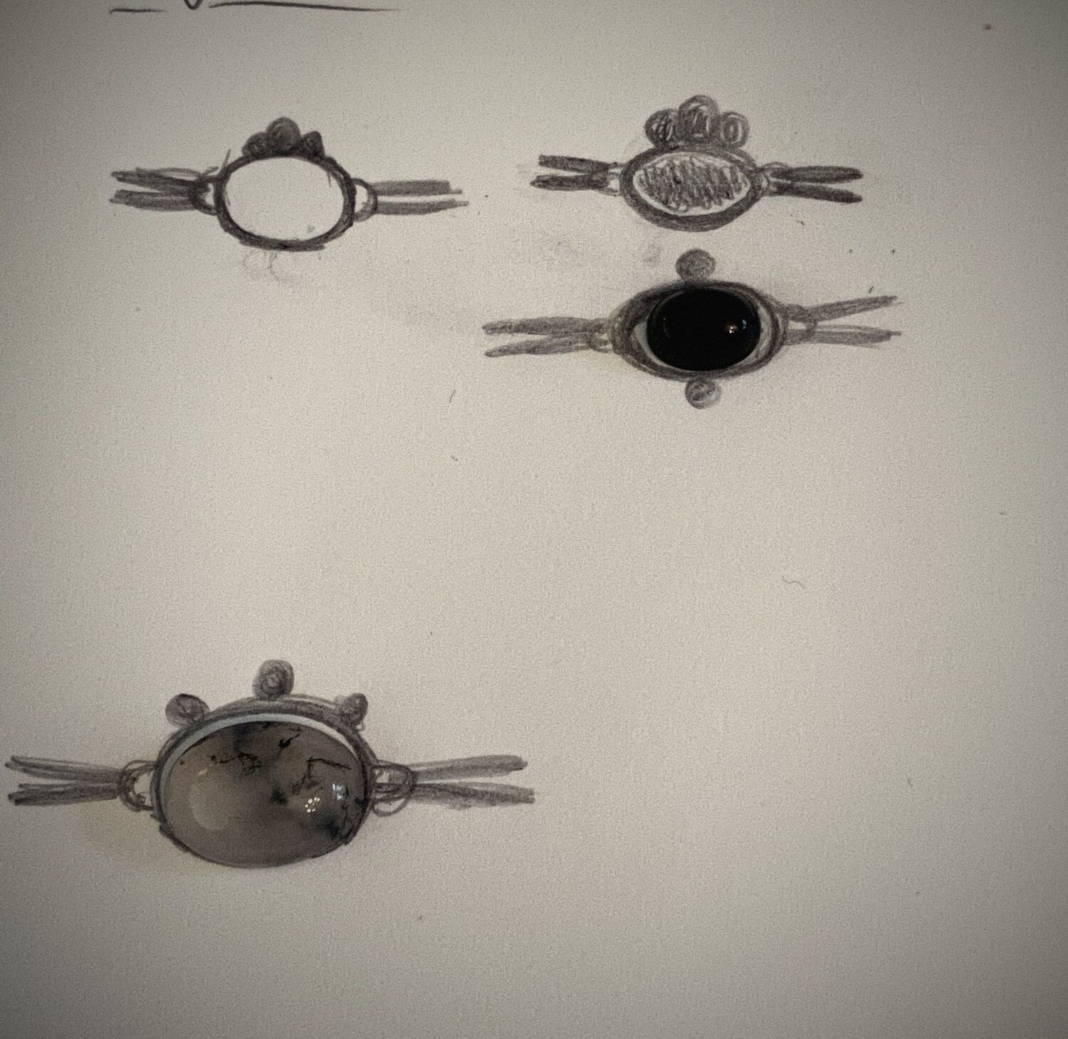 Potloodschetsen van hangers met cabochons op wit papier
