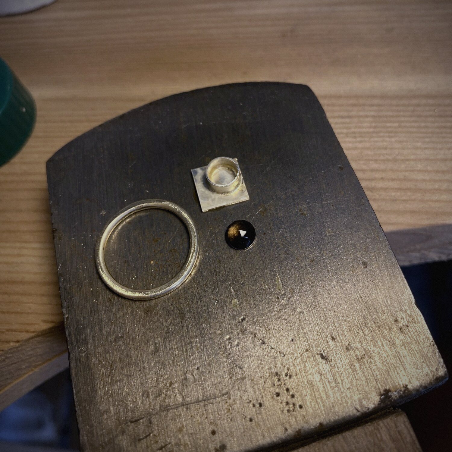 Gouden ring in wording op het stalen werkblok, met een kleine steen